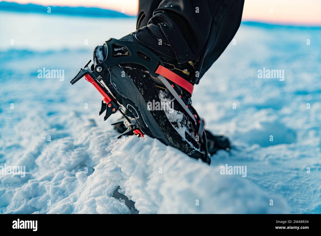 Mountain Boot mit Steigeisen während der Wanderung in den Bergen im Winter. Stockfoto