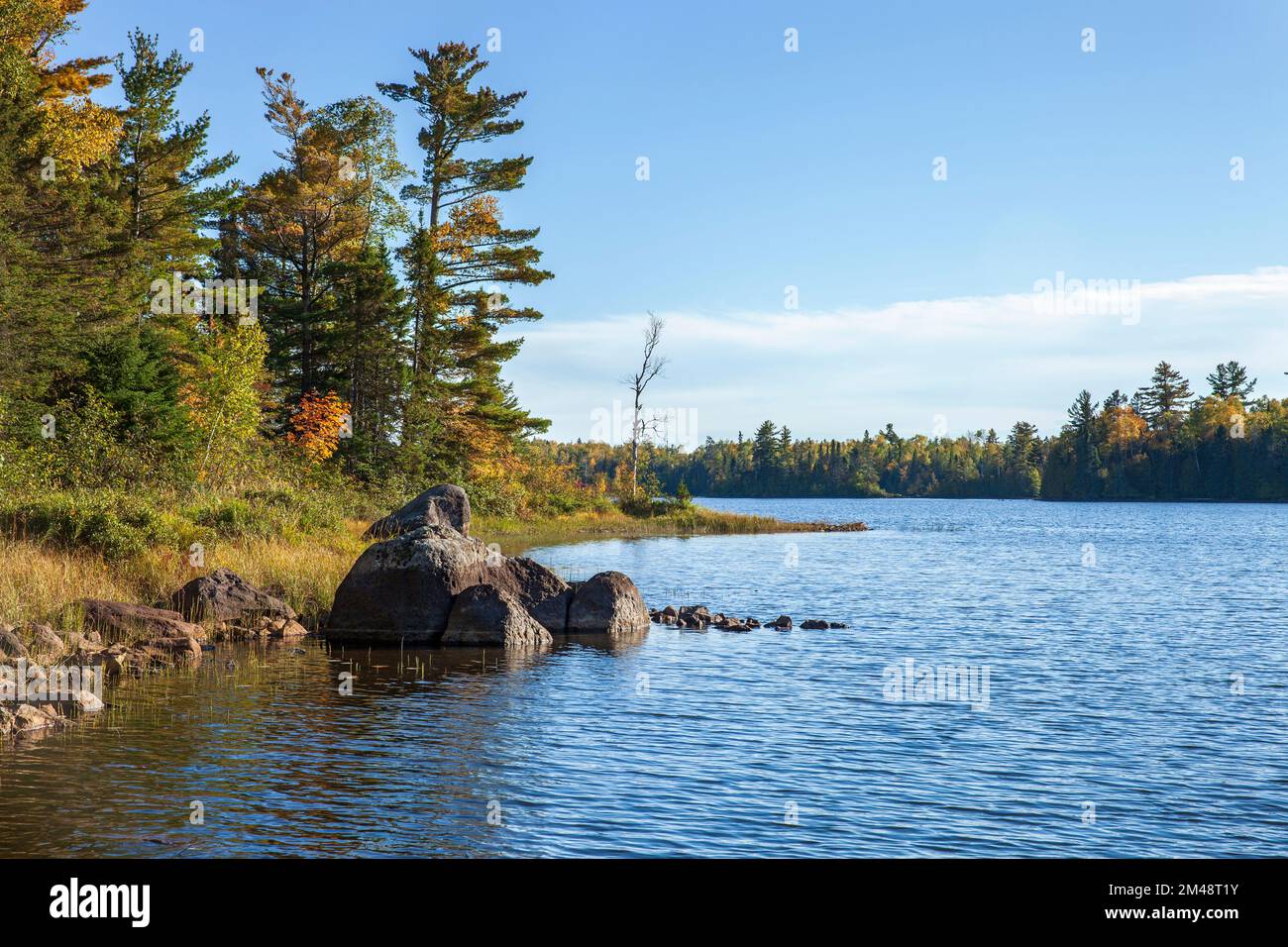 Nördlicher Minneosta-See mit Bäumen und Felsen während des Herbstes Stockfoto