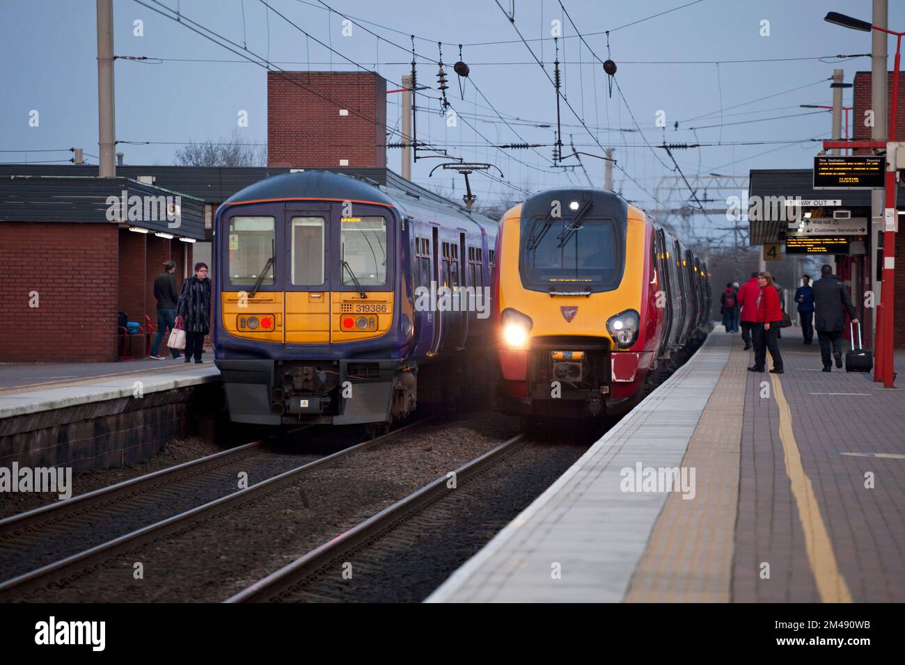 Virgin Train Diesel voyager Train und Northern Rail Class 319 Electric Train am Bahnhof Wigan North Western an der Westküste der Hauptlinie. Stockfoto