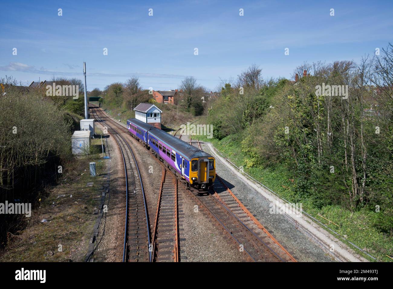 Poulton Le Fylde Signalbox der mechanischen Eisenbahn mit einem Sprinterzug der Northern Rail Klasse 156, der mit dem GSMR-Mast und der geschlossenen Linie rechts vorbeifährt Stockfoto