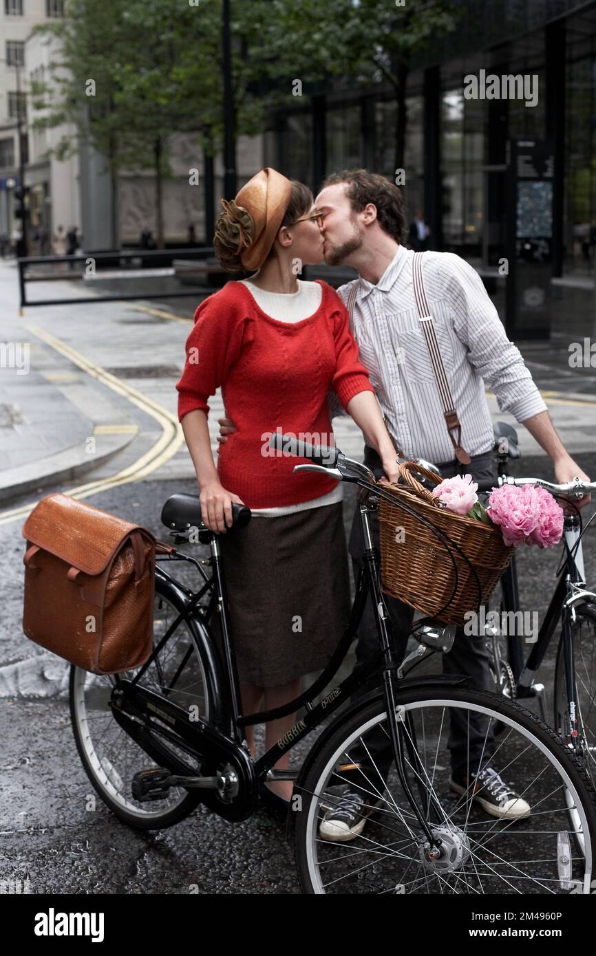 Ein Paar mit einem Fahrrad, das sich draußen auf der Straße küsst Stockfoto