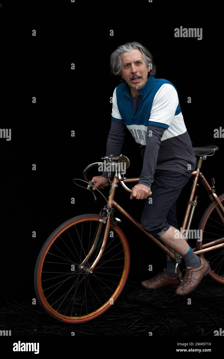 Fahrradsammler mit altem Retro-Fahrrad und schwarzem Hintergrund Stockfoto