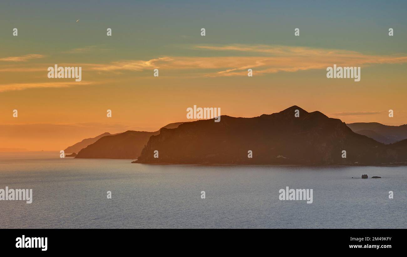 Sonnenuntergang, Abenddämmerung, felsige Küsten in einer Reihe, sandiger und blauer Himmel, Pentati, Dorf über der Bucht von Agios Gordios, Insel Korfu, Ionische Inseln, Griechenland Stockfoto