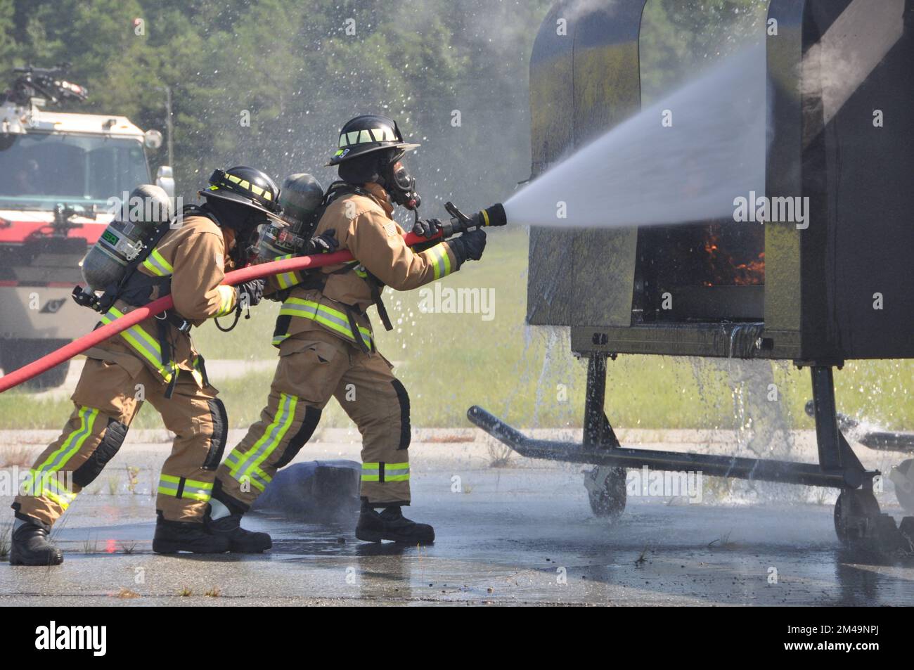 Feuerwehrleute des 908. Airlift Wing 908. Civil Engineer Squadron löschen ein Feuer während einer Übung mit einem Feuerwehrtrainer für Hubschrauberflugzeuge am 4. August 2022 in Fort Benning Georgia. Die 908. Feuerwehrmänner führten gemeinsam mit der Feuerwehr von Fort Benning ihre erste gemeinsame Interoperabilitätsschulung durch und setzten den Helikoptertrainer ein, um ihre Ausbildung zur Vorbereitung auf die 908 AW-Remission zur formellen Trainingseinheit der Air Force für den MH-139A Grey Wolf Hubschrauber zu beschleunigen. (USA Air Force Photo von Bradley J. Clark) Stockfoto