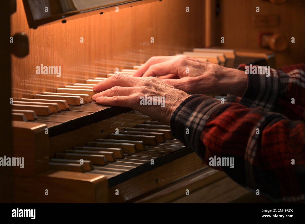 Alte Hände eines Organisten, der auf der Orgeltastatur spielt, auch manuelles Musikinstrument in der Kirche genannt, Kopierraum, ausgewählter Fokus, n Stockfoto