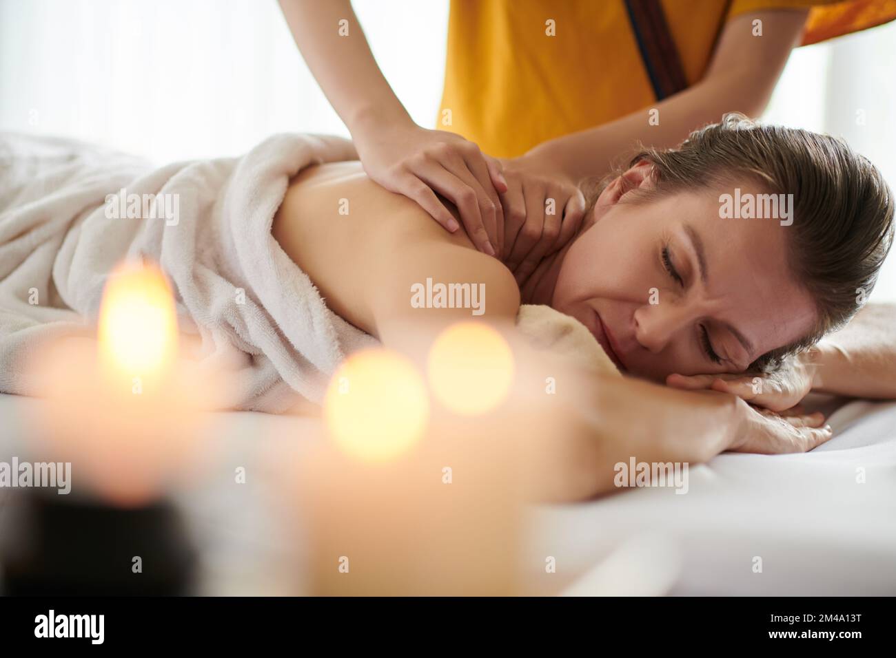 Ältere Frau bekommen entspannende Schultermassage im Spa Salon Stockfoto
