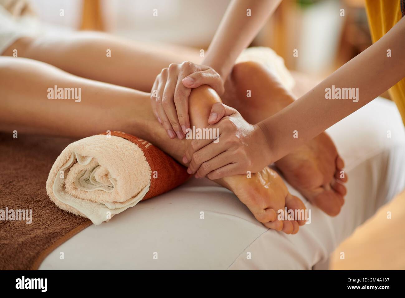 Eine Frau, die nach einem langen Tag eine entspannende Fußmassage mit Ölen bekommt Stockfoto