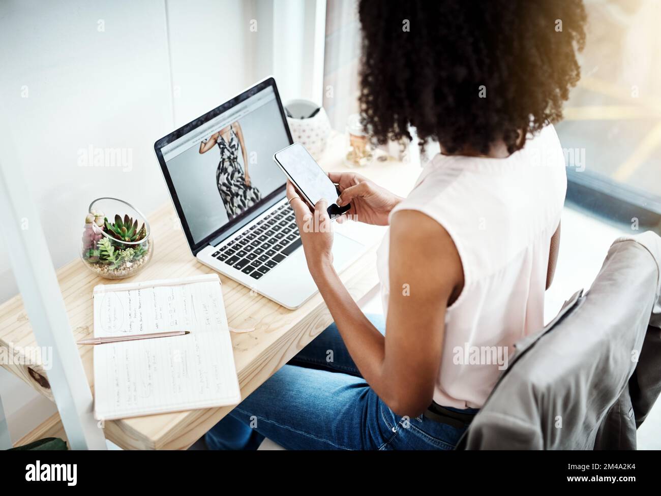 Verbindung wird hergestellt. Aufnahme einer unbekannten jungen Geschäftsfrau, die eine SMS liest, während sie im Home Office arbeitet. Stockfoto