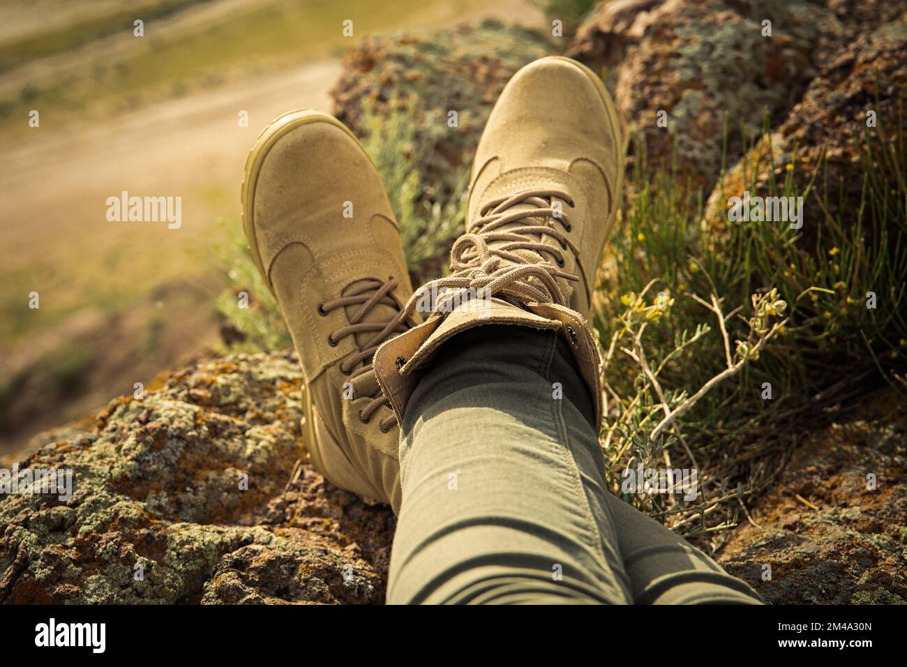 Hohe Wanderschuhe auf weiblichen Beinen in felsigem Gelände im Safari-Stil Stockfoto