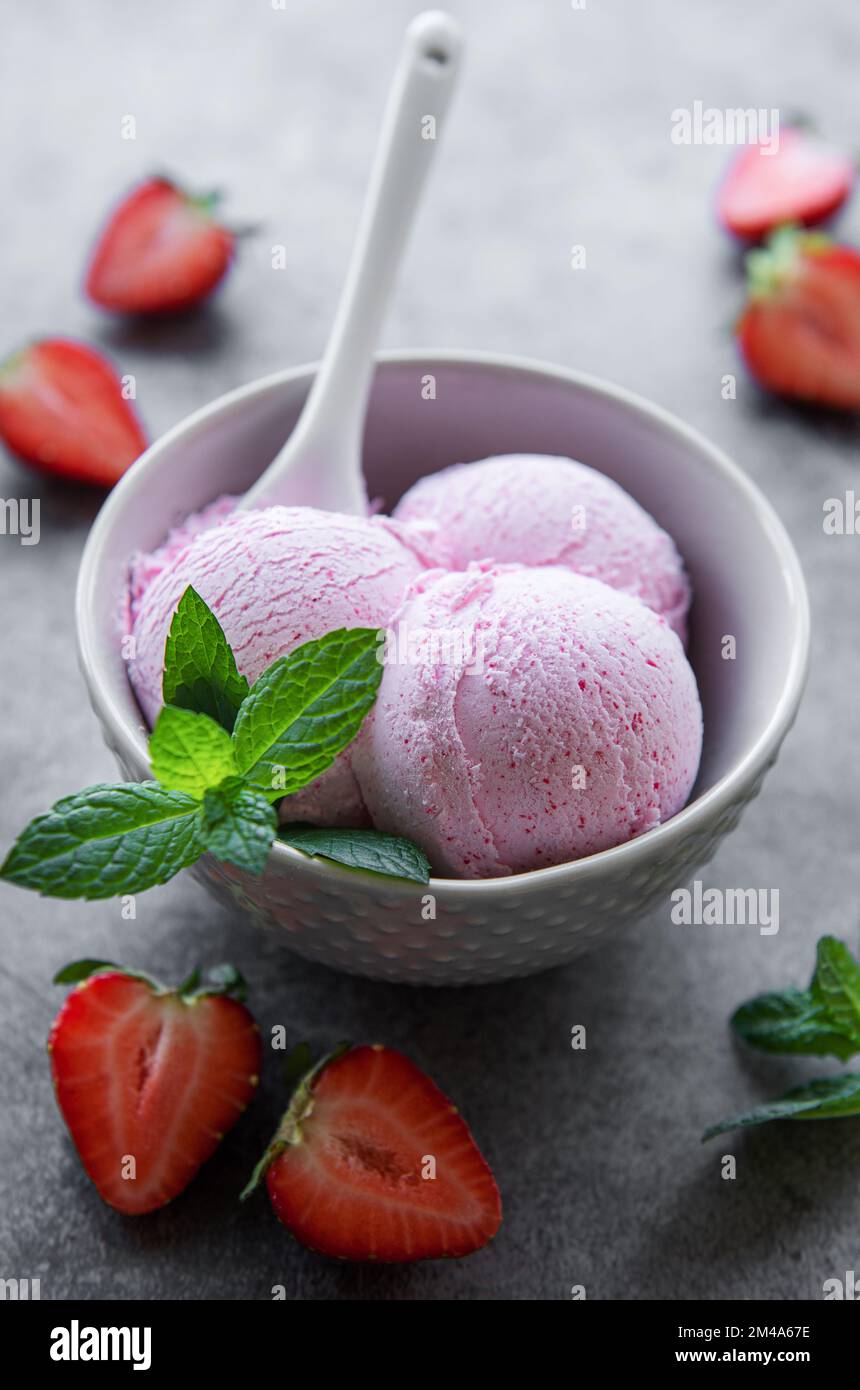 Hausgemachtes Erdbeereis mit frischen Erdbeeren. Süßes Beerendessert im Sommer. Konkreter Hintergrund Stockfoto