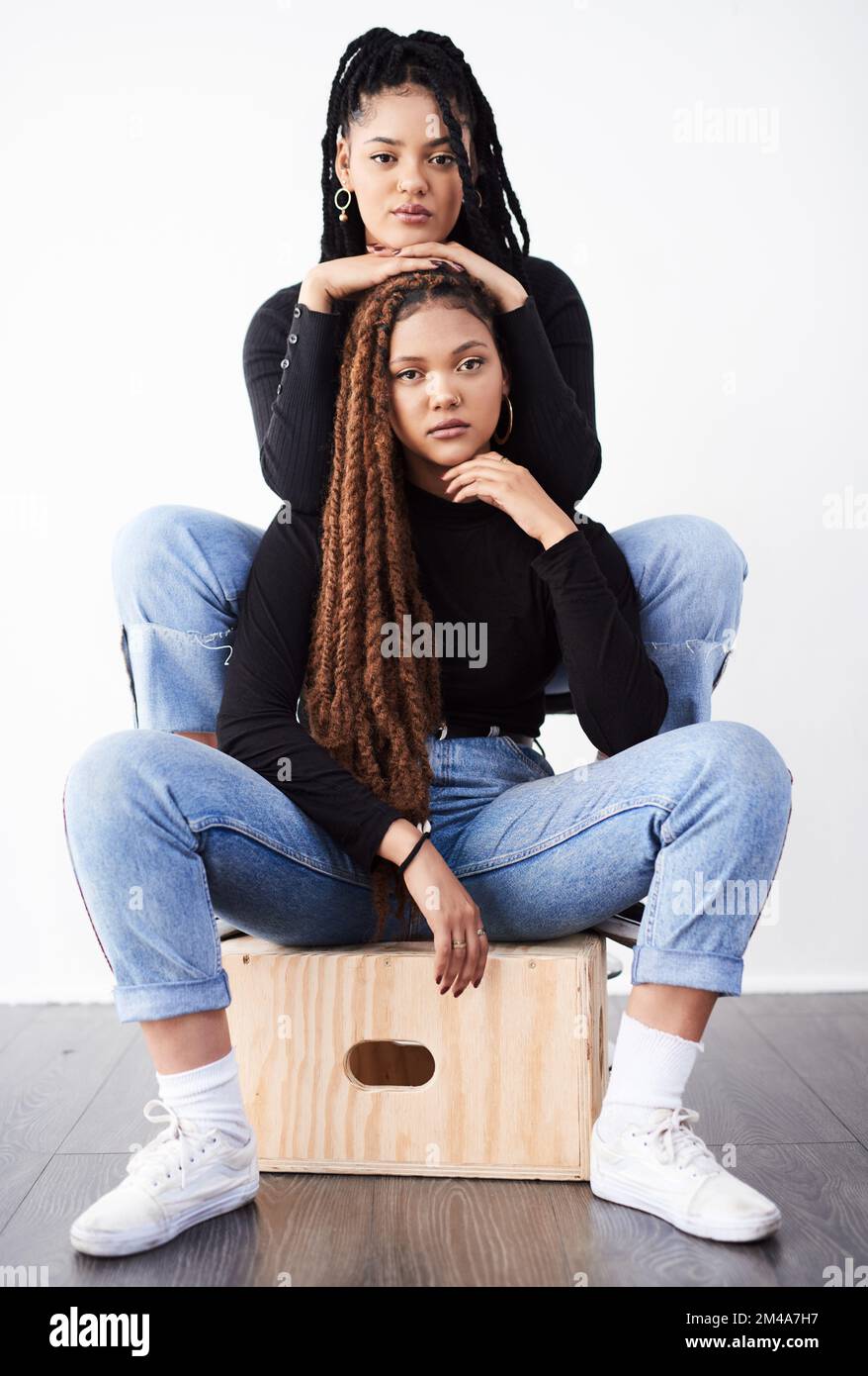 Modisch und funky. Studioaufnahme von zwei wunderschönen jungen Frauen, die vor grauem Hintergrund posieren. Stockfoto