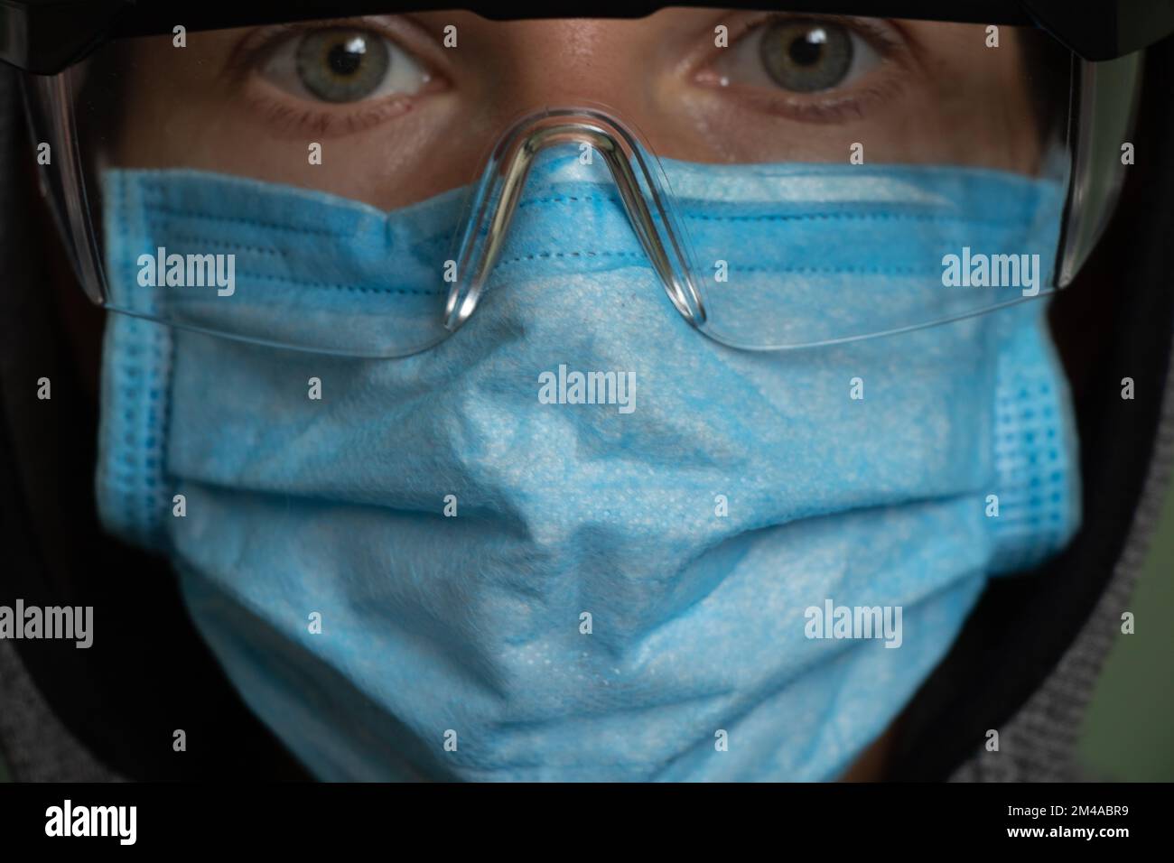 Mädchen mit medizinischer Maske und Schutzbrille allein Stockfoto