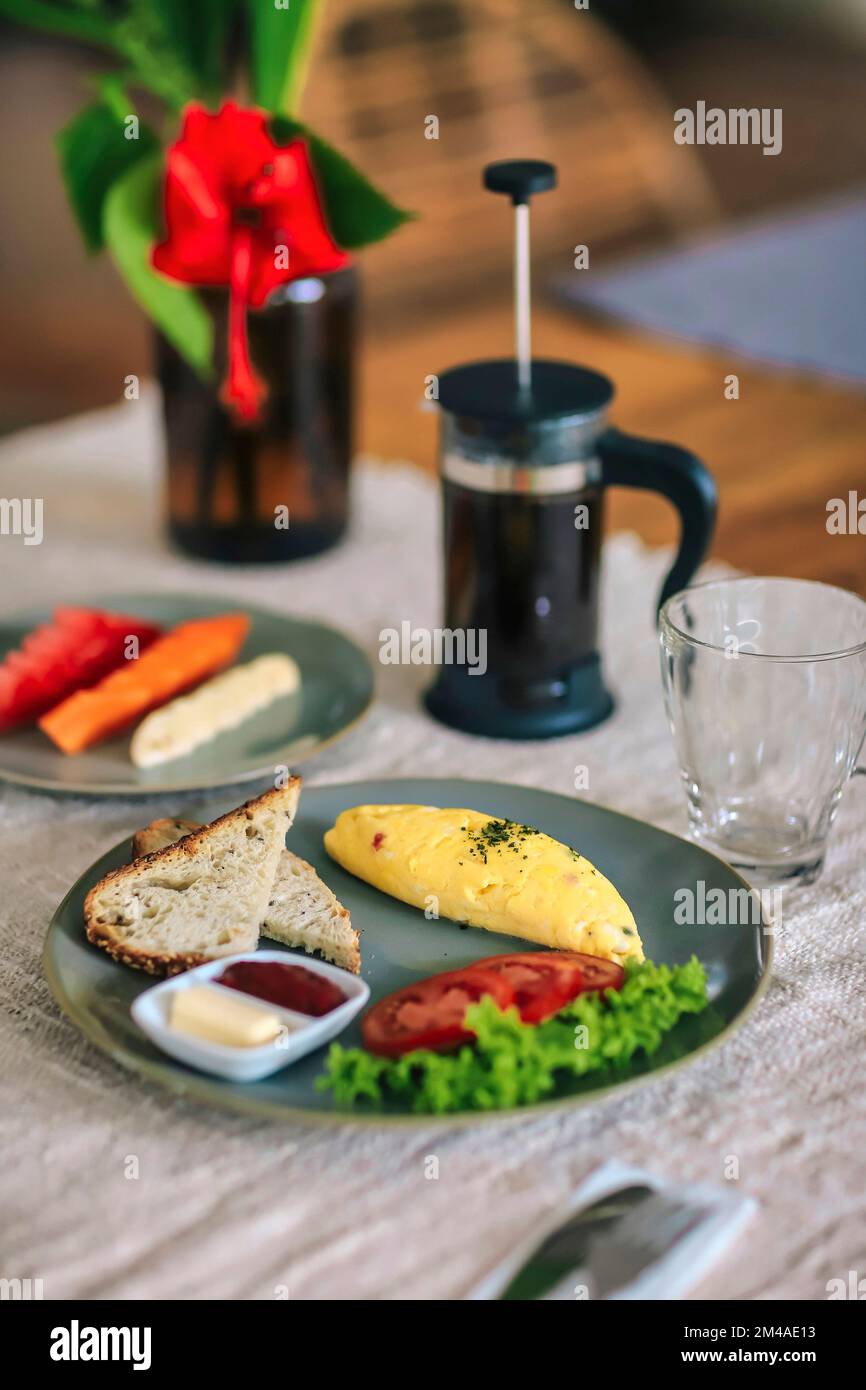 Köstliches Omelette mit Tomaten und Obst auf dem Tisch Stockfoto