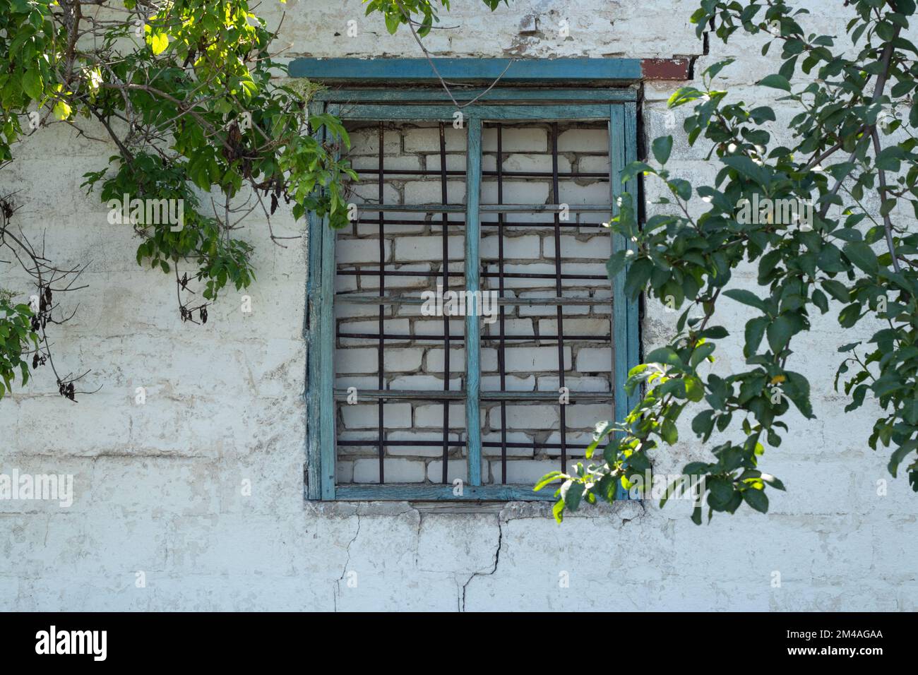 Backsteinfenster und Gitter in einem verlassenen Haus Stockfoto