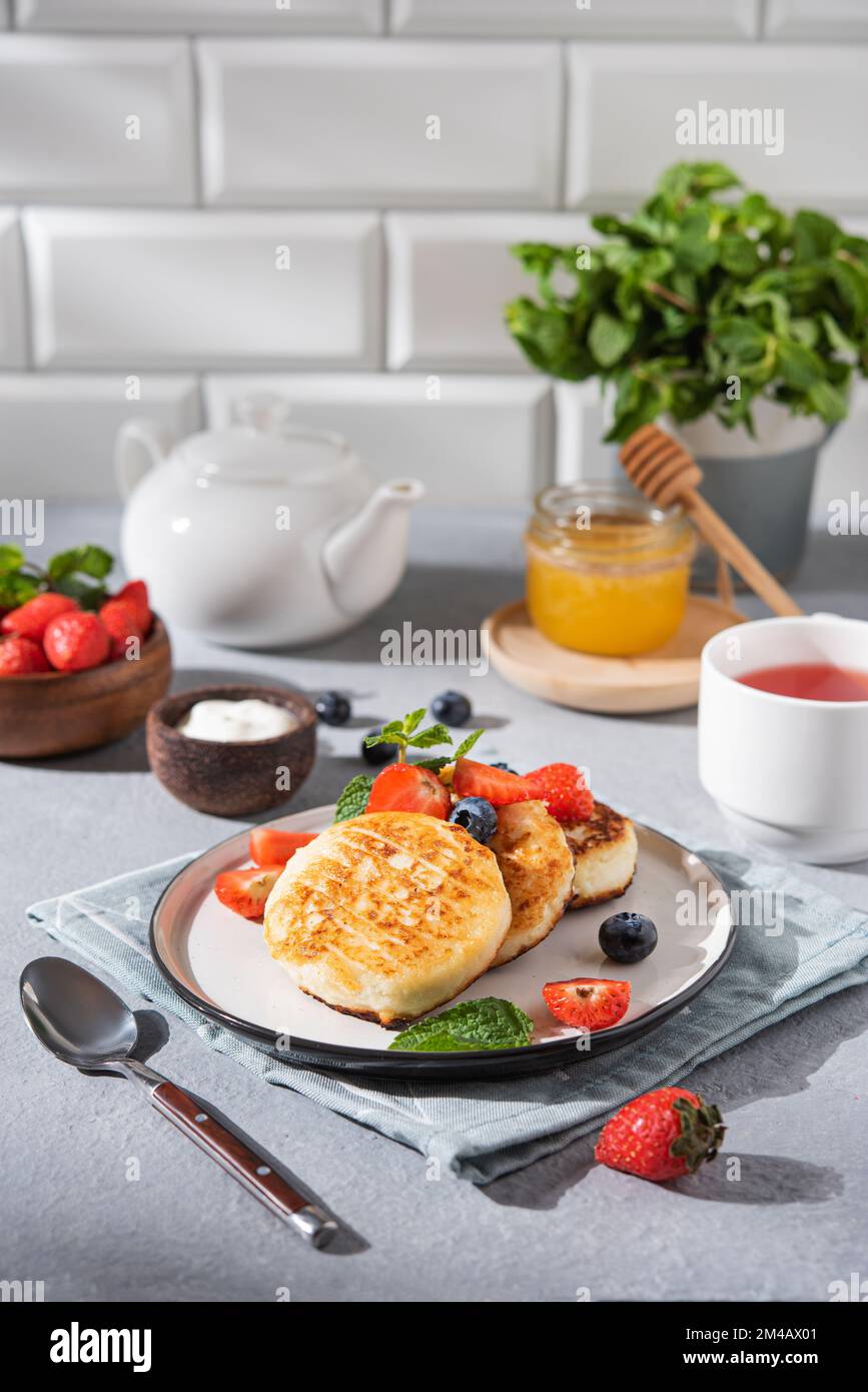 Pfannkuchen mit Hüttenkäse oder Syrniki mit frischen Beeren, Honig und ...
