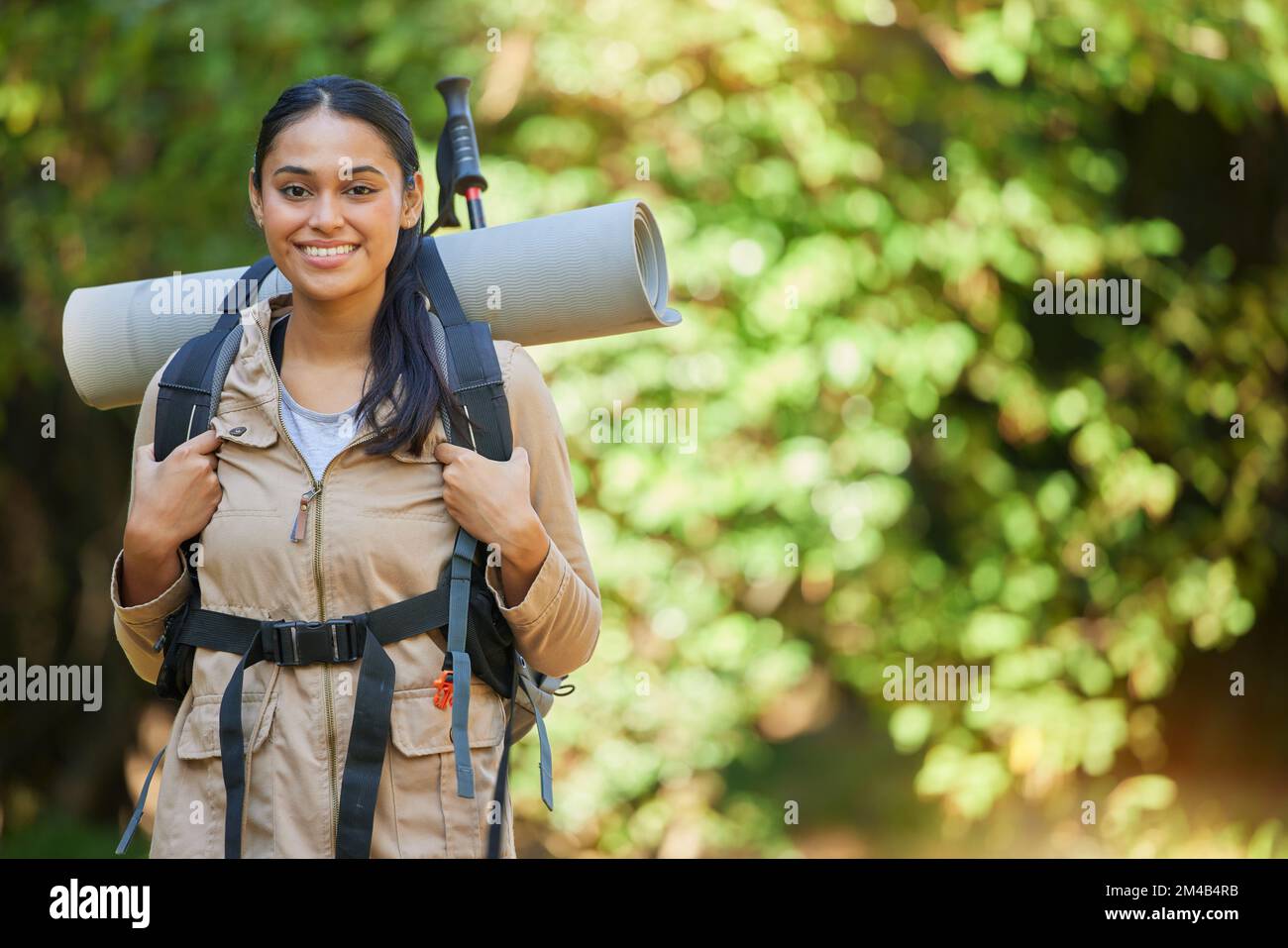 Wandern in der Natur mit einem Rucksack und Campingausrüstung im Wald, einer Frau oder einem Camper in einem erholsamen Urlaub in Neuseeland. Reisen, Porträt oder glücklich Stockfoto