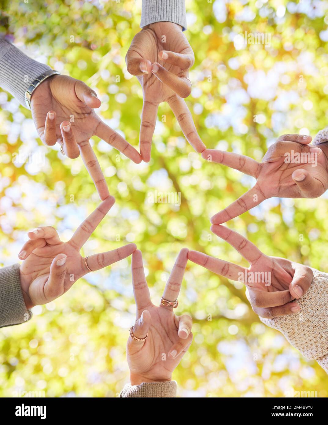 Stern, Finger und eine Gruppe von Personen, die von unten verknüpft werden, um Unterstützung, Community und Zusammenarbeit mit Freundschaft zu erhalten. Freunde, Form und Handbewegung für Stockfoto
