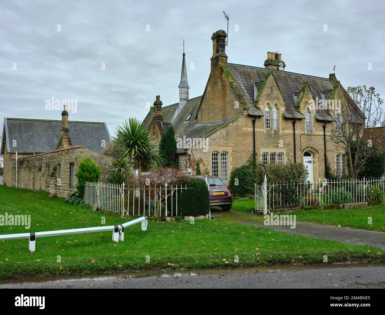 Blick auf die Hovingham Church of England School mit einem traditionellen 2-stöckigen Steinhaus mit Schieferdach. Hovingham Stockfoto