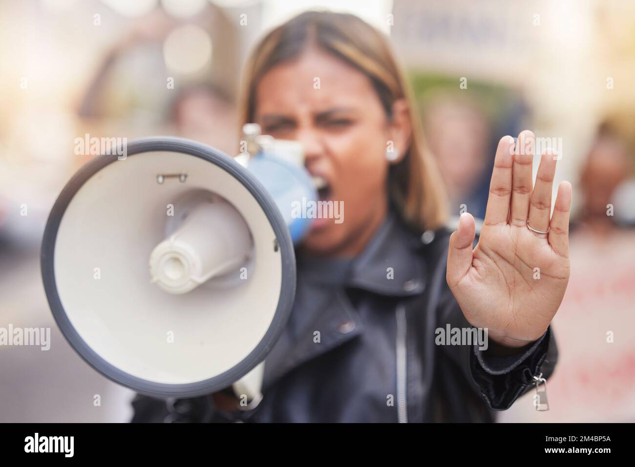 Frau, Megafon und Hand in Protest, um geschlechtsspezifische Gewalt, Diskriminierung oder Gleichberechtigung in der Stadt zu stoppen. Wütende weibliche Aktivistin schreit, protestiert Stockfoto