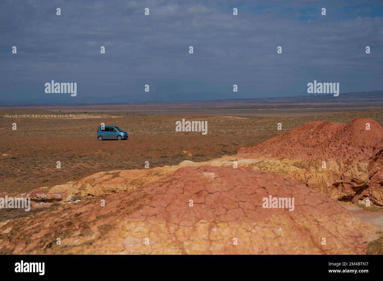 Landschaft mit bunten Tondünen. Mars auf Erden. Blaues Auto. Stockfoto