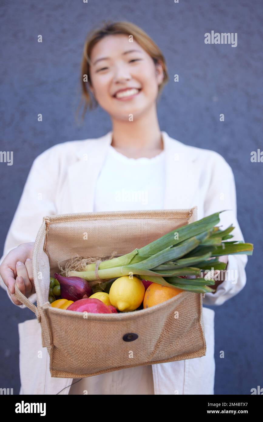 Lebensmitteleinkäufe, Gemüse und Frau mit einer Tasche in der Stadt, Supermarkt Essen und zufrieden mit dem Verkauf aus dem Obstgeschäft. Obst und Gemüse, Lächeln und Asiaten Stockfoto
