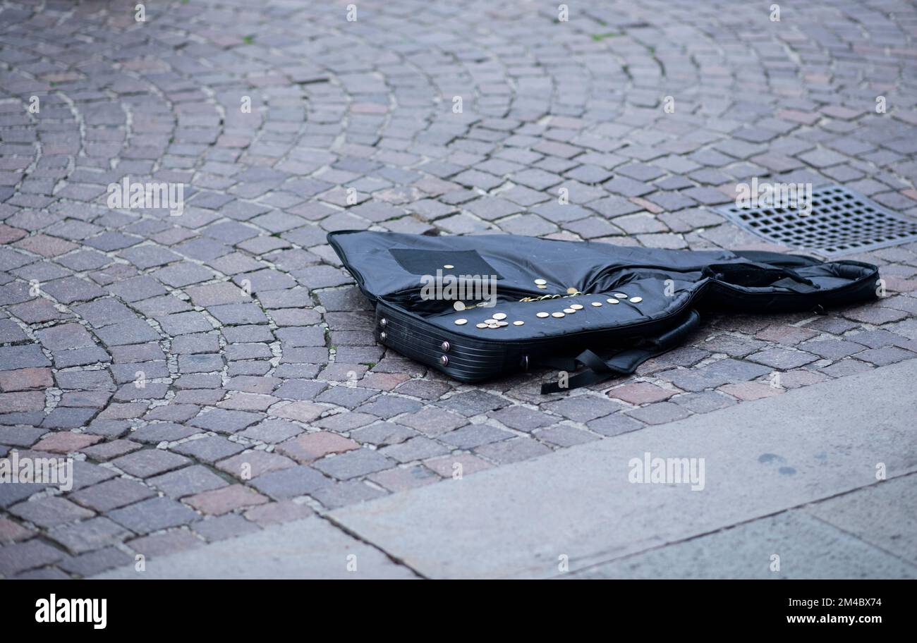 Gitarrenkoffer eines Straßenkünstlers mit Münzen auf einer italienischen Straße Stockfoto