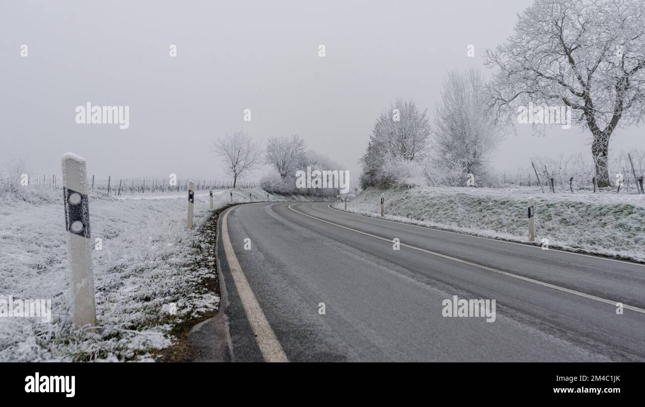 Winterstraße im Schnee. Asphaltstadtstraße mit Eis bedeckt. Stockfoto
