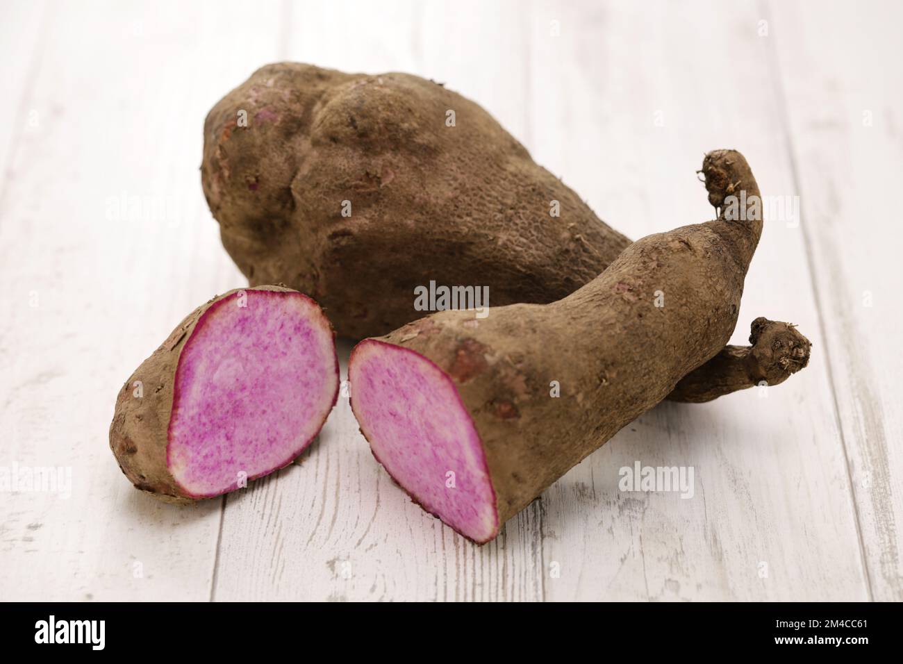 Violette Yamswurzeln isoliert auf weißem Holzhintergrund Stockfoto