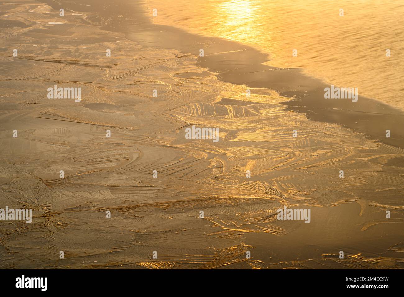 Sonnenaufgangsreflexionen im Eis, offenes Wasser eines Biberteichs im Frühling, Greater Sudbury, Ontario, Kanada Stockfoto