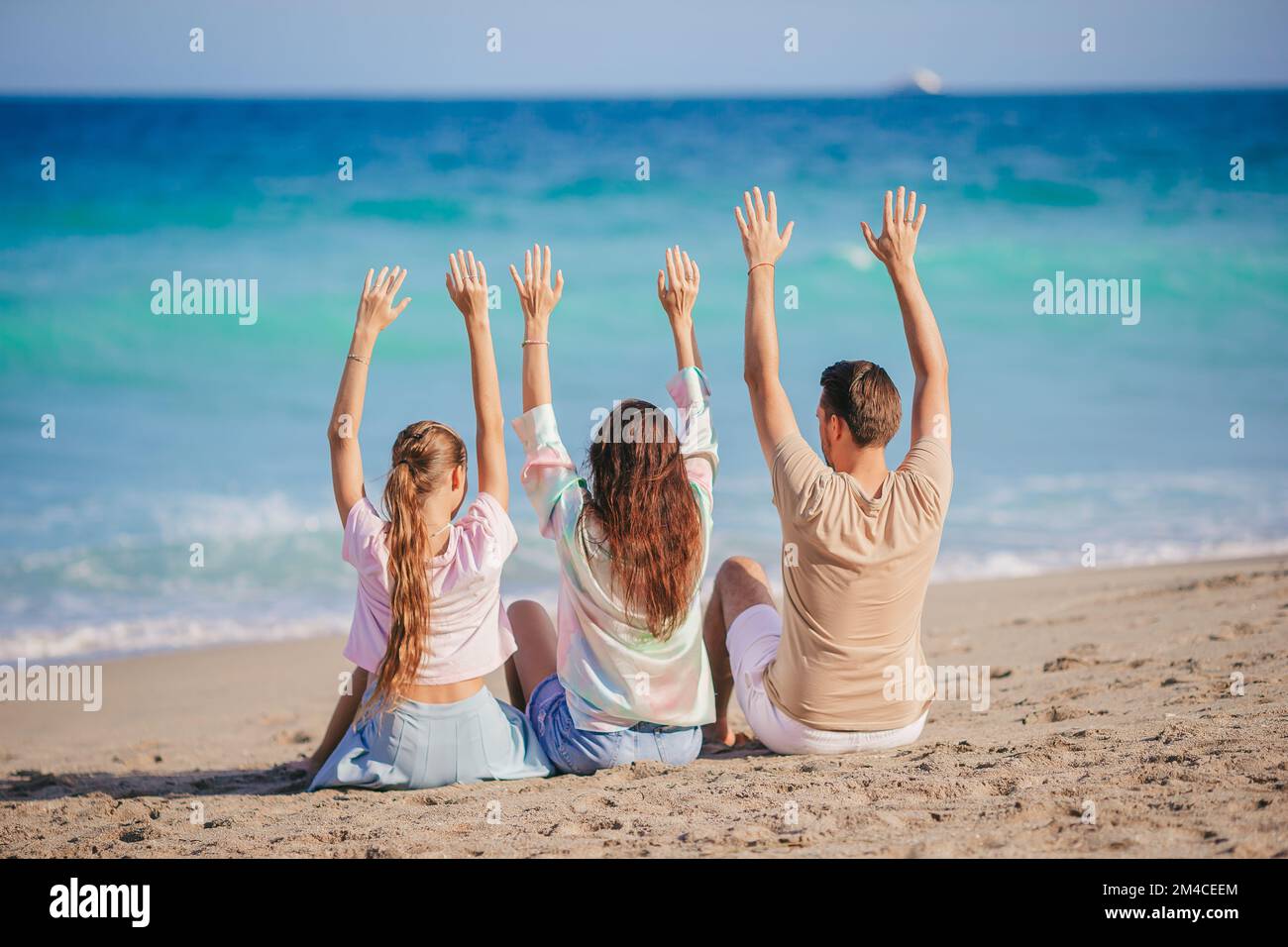 Eine dreiköpfige Familie am Strand, die Spaß zusammen hat Stockfoto
