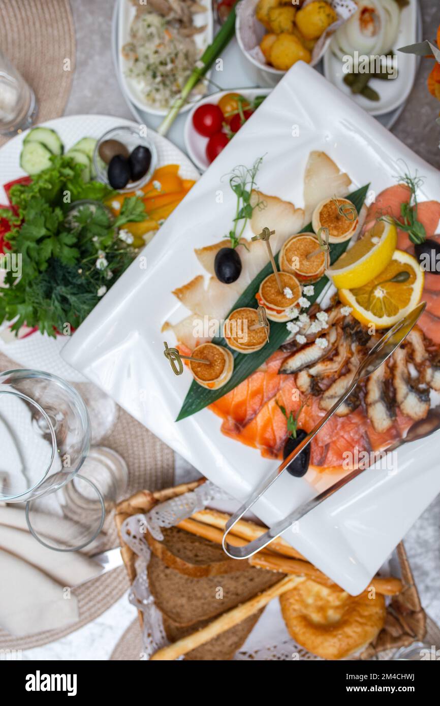 Ansicht der Fischschnitte im Sortiment von oben auf einem festlichen weißen Teller. Stockfoto