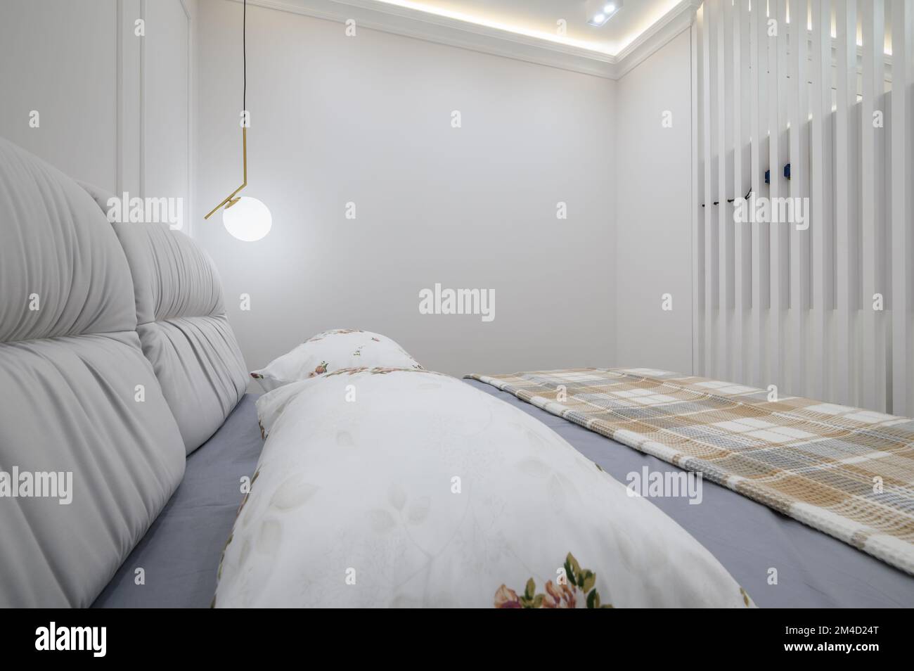 Stilvolles Interieur aus grauem und weißem Schlafzimmer mit komfortablem Bett Stockfoto