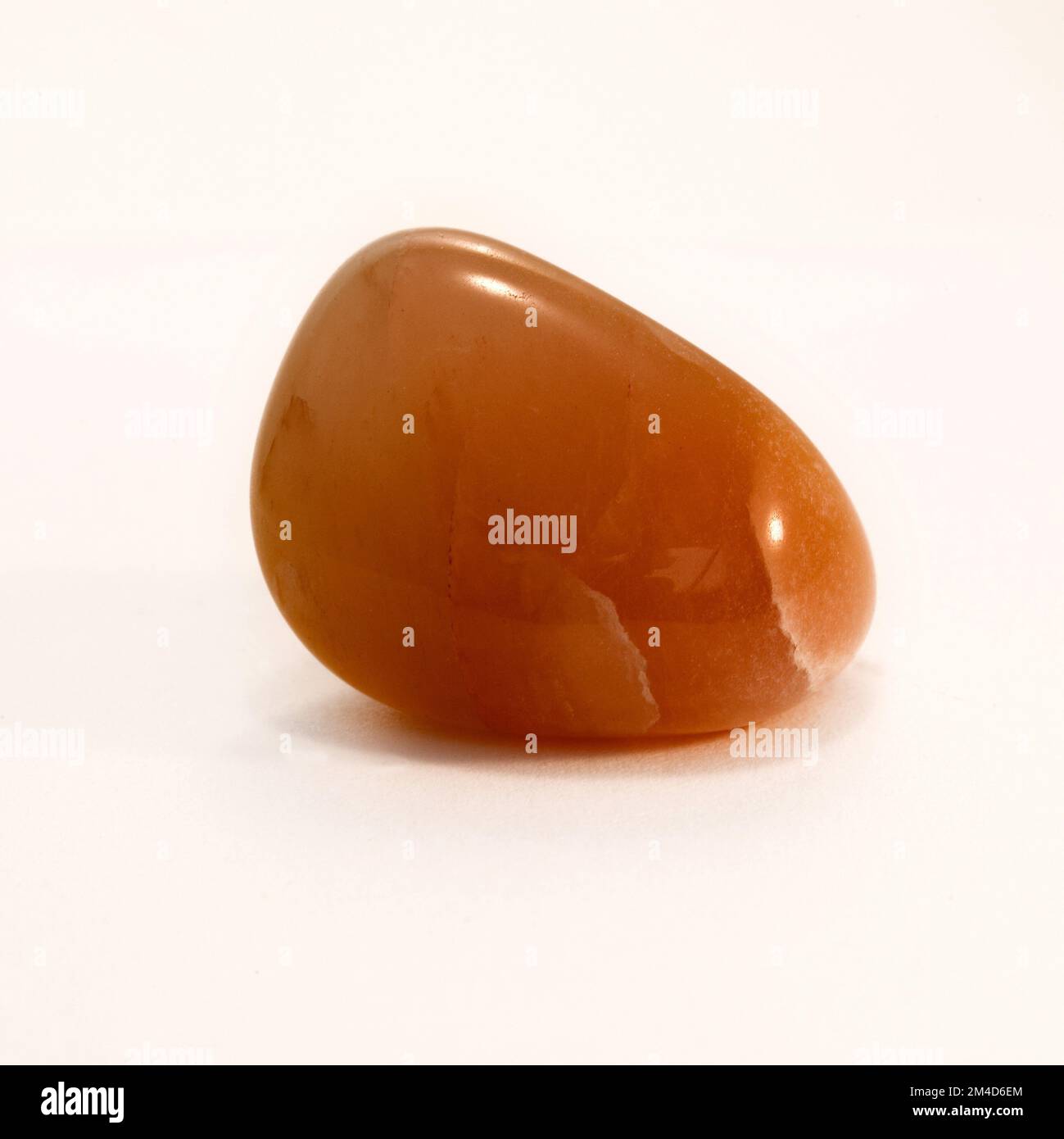 Makro-Nahaufnahmen einer polierten " Aventurin Peach ", einem Schmuckstein aus Kristall, der in der Kristallheilungstherapie verwendet wird Stockfoto