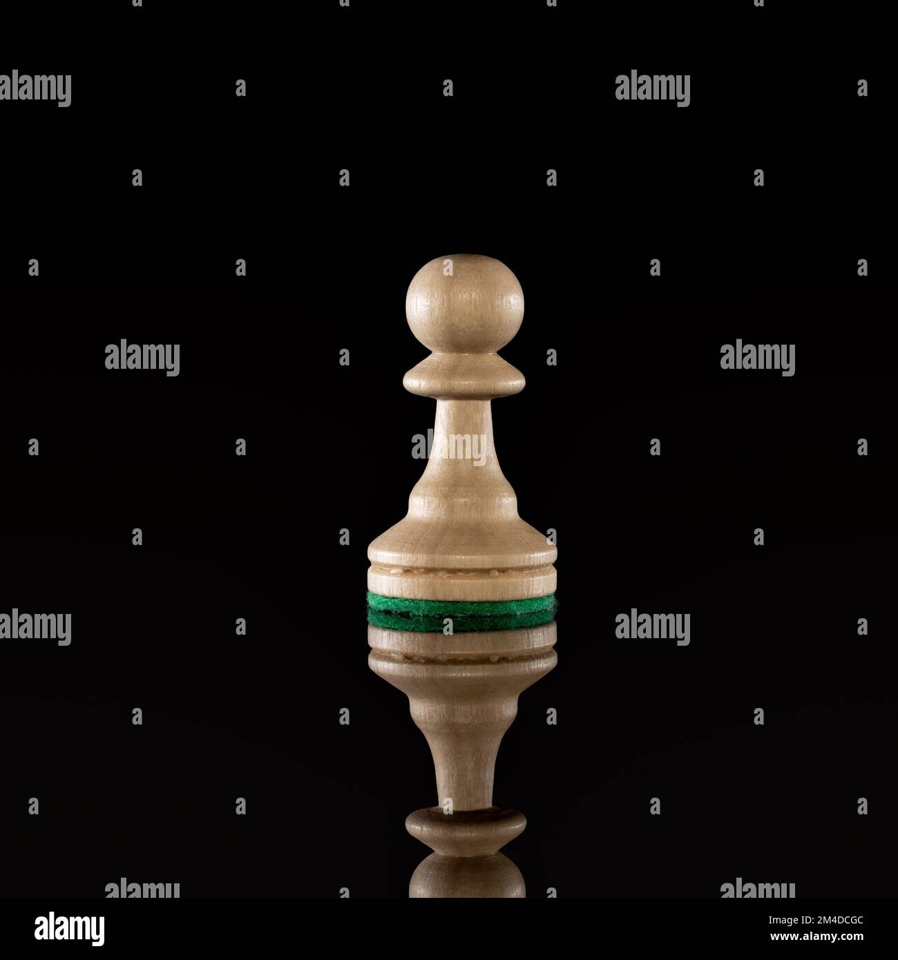 Weißer Schachbauer aus Holz, isoliert auf dunklem Hintergrund mit transparenter Reflexion auf dem Boden Stockfoto