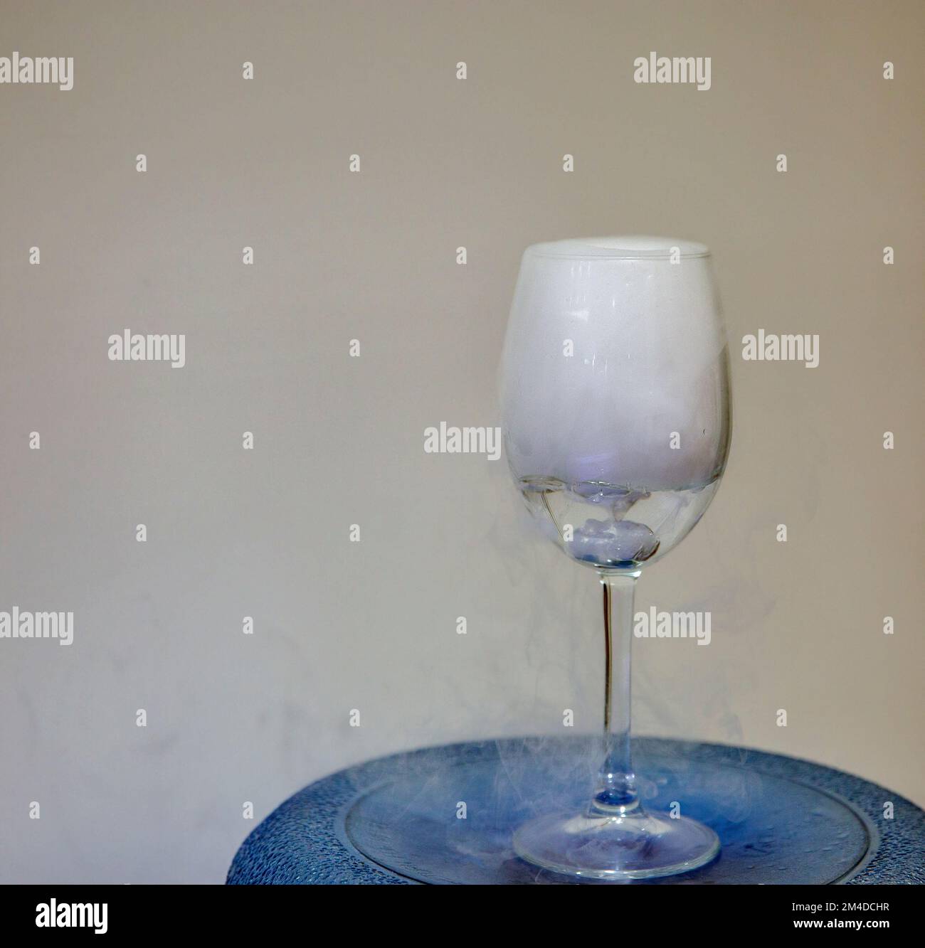 Klappglas mit weißer Nebel-Klappscheibe. Chemische Reaktion von Trockeneis mit Wasser. Stockfoto