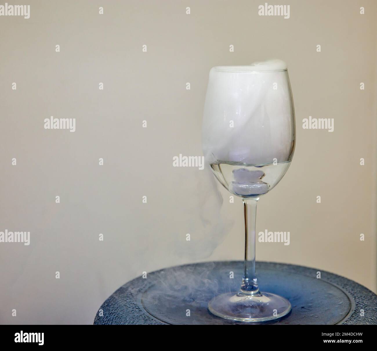 Klappglas mit weißer Nebel-Klappscheibe. Chemische Reaktion von Trockeneis mit Wasser. Stockfoto