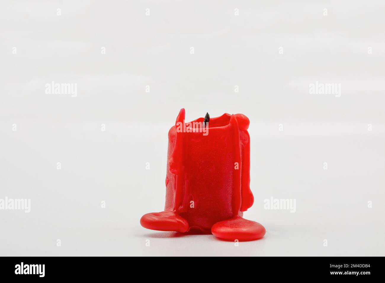Kleine, rote Kerze, Nahaufnahme auf weißem Hintergrund Stockfoto