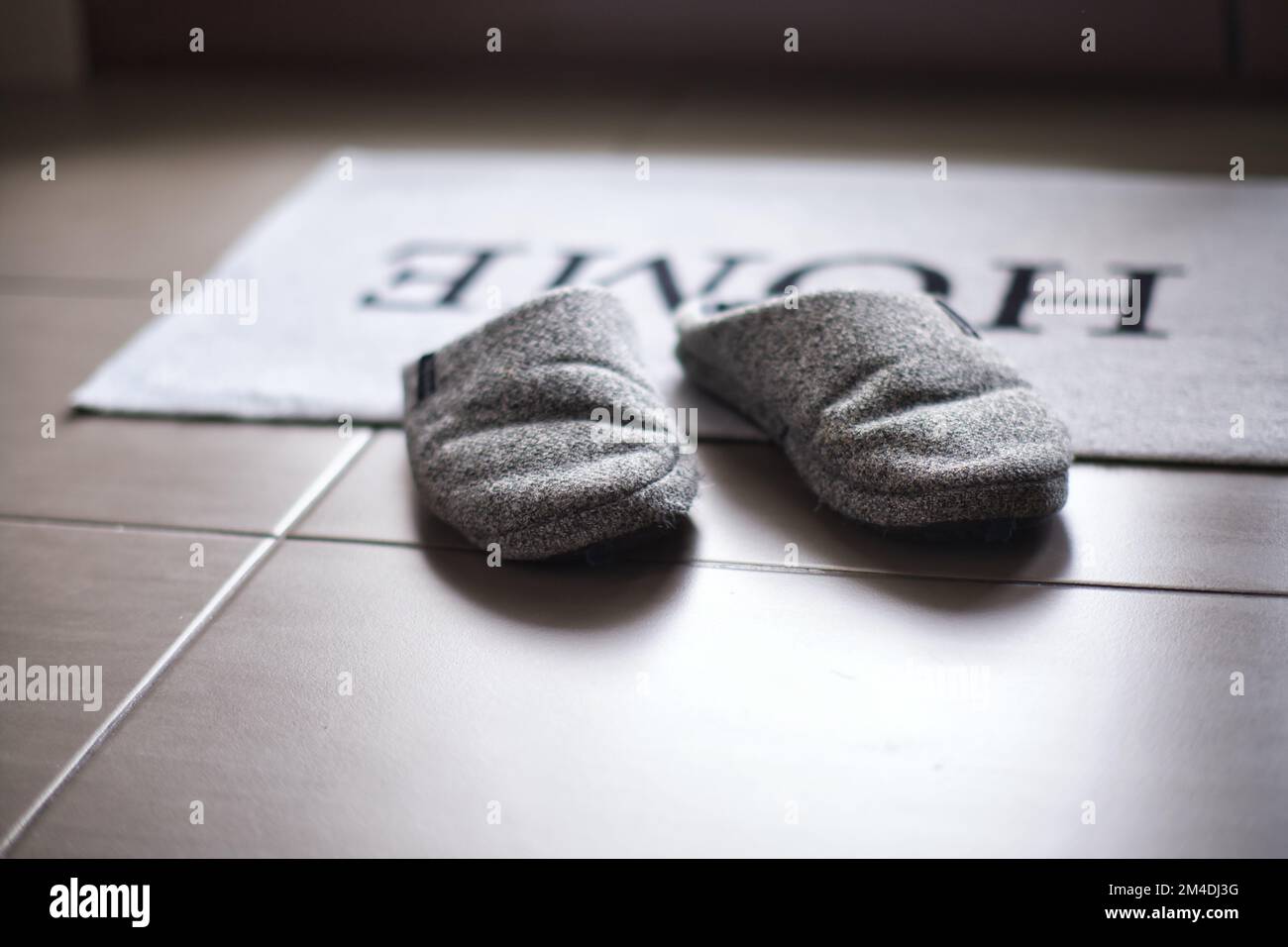 Pantoffeln auf einem Teppich am Eingang mit geringer Tiefenschärfe Stockfoto
