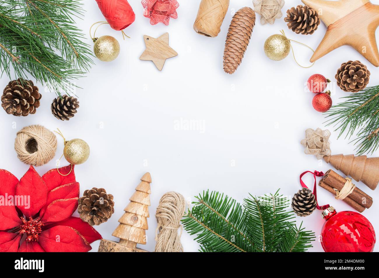 Weihnachtshintergrund, Kiefernzapfen, Holzornamente und -Dekorationen, Stoffblume, Zuckerstangen, Tannenbäume auf weißem Tisch Stockfoto