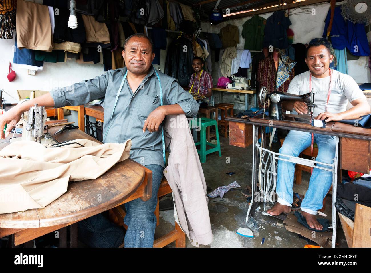 Ein Schneider und seine Mitarbeiter arbeiten in ihrem kleinen Unternehmen. Stockfoto