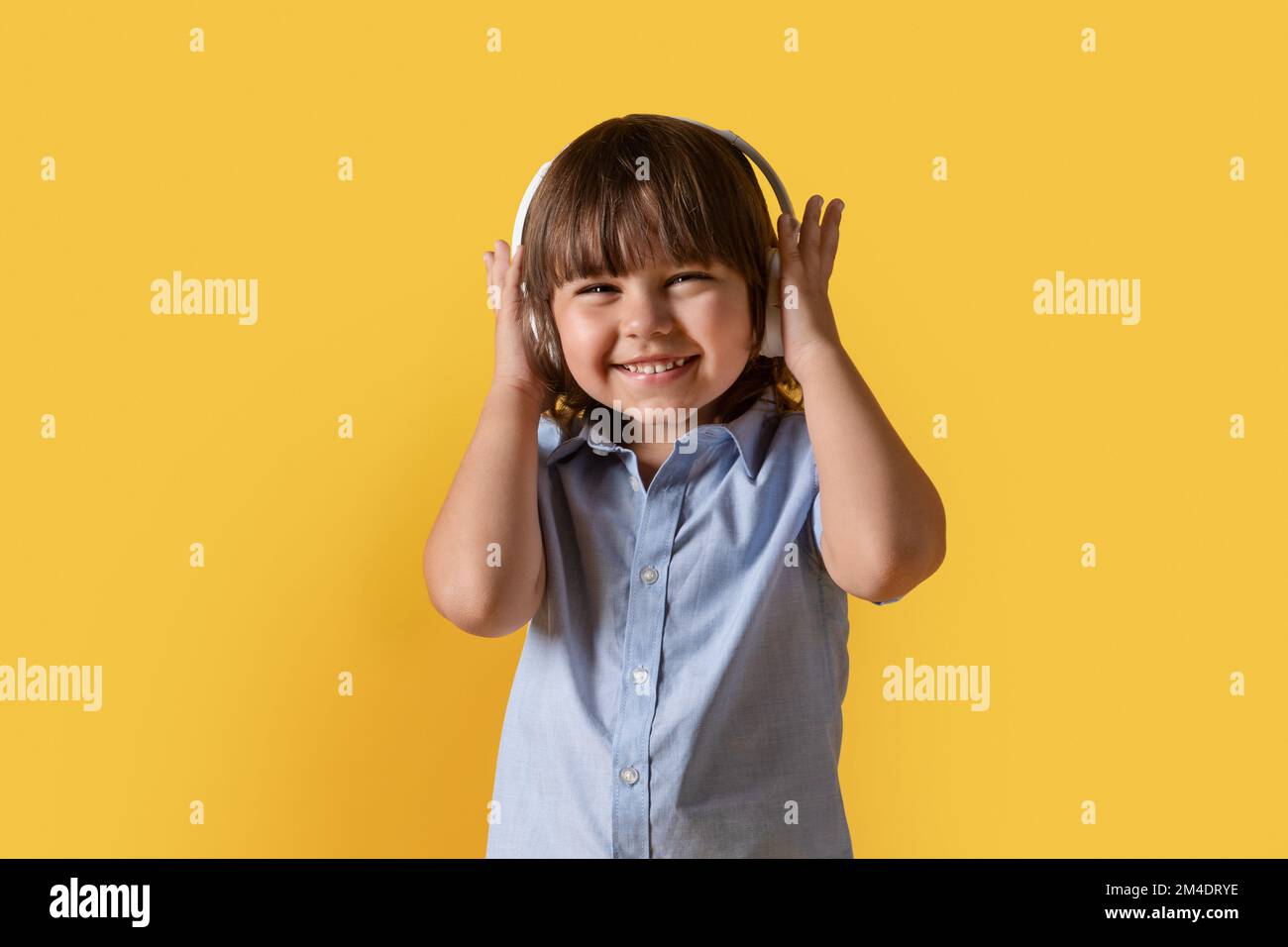 Kleiner Musikliebhaber. Studioporträt eines glücklichen kleinen Jungen mit kabellosen Kopfhörern, der großartigen Klang dynamischer Titel genießt Stockfoto