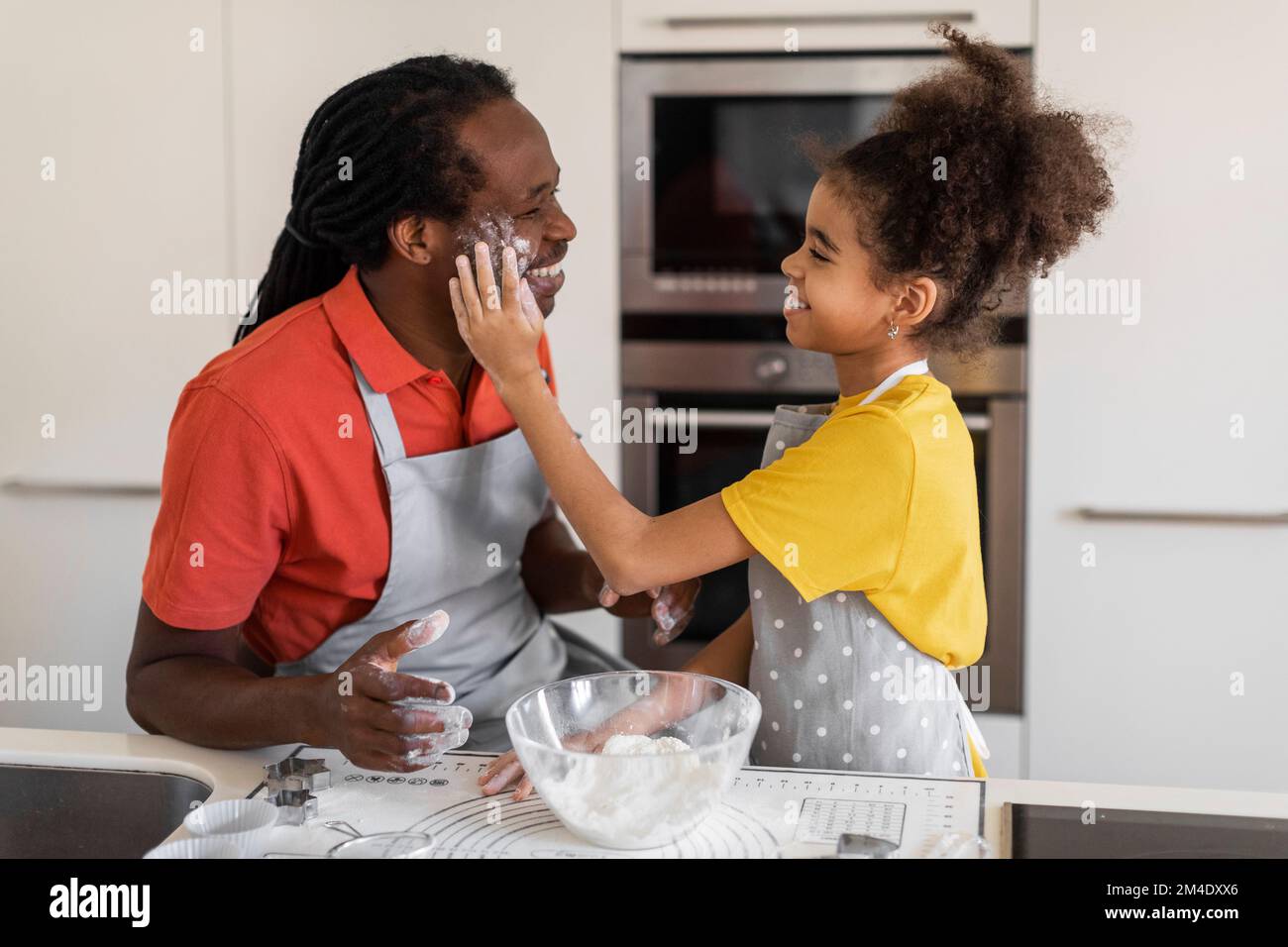 Vatertag. Black Girl Hat Spaß Beim Backen Mit Dad In Kitchen Stockfoto