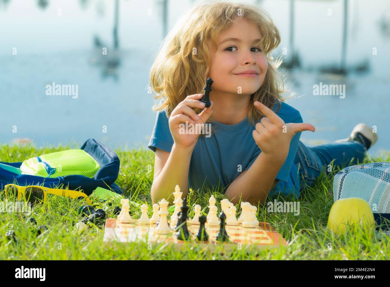 Kind spielt Schach. Ein kluger Junge, der an Schach denkt. Stockfoto