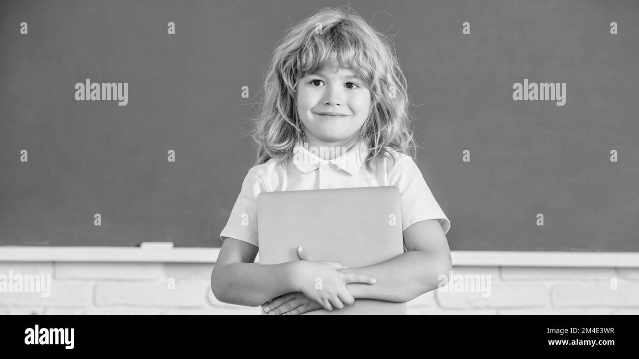 E-Learning. Kind studiert mit Computer. Fröhlicher Teenager Junge im Klassenzimmer. Zurück zur Schule. Stockfoto