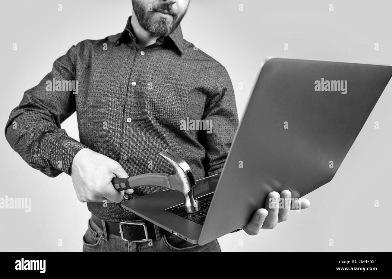 Virenangriff. Mann beschnitten Ansicht traf Laptop mit Hammer. Virenbedrohung. Virenbefall-Software Stockfoto