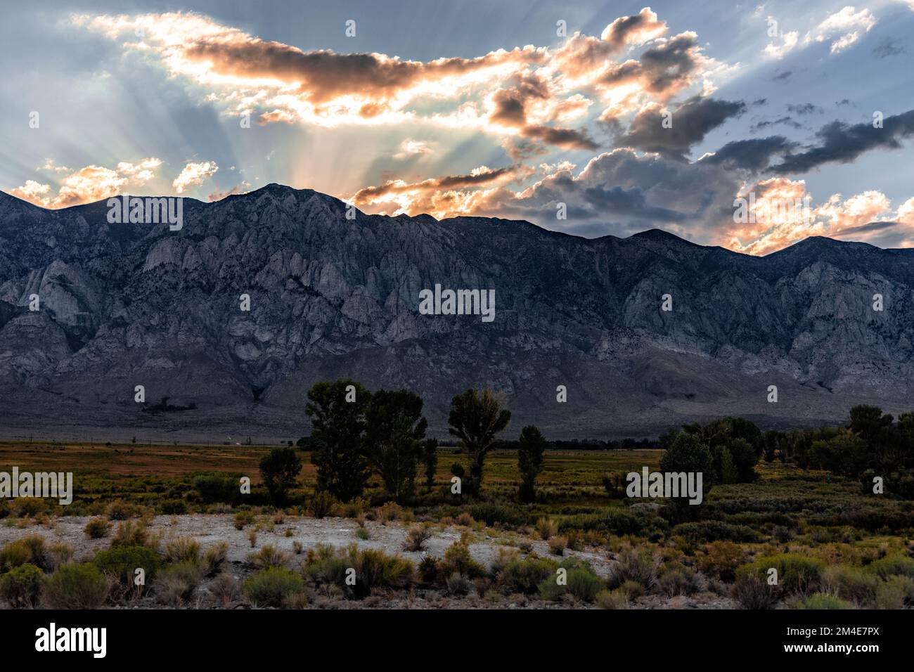 Das helle Sonnenlicht und die bunten Wolken über den Bergen im Owen Valley, Kalifornien Stockfoto