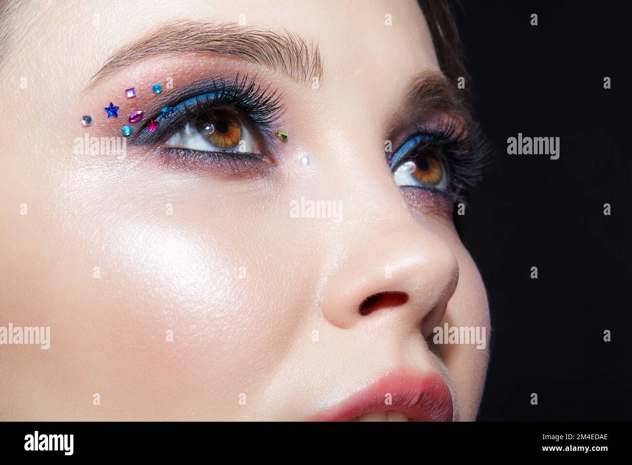 Nahaufnahme des menschlichen Frauengesichts. Frau mit natürlichem Gesicht  und Augen Beauty Make-up mit blauem Lidschatten und Strasssteinen  Stockfotografie - Alamy