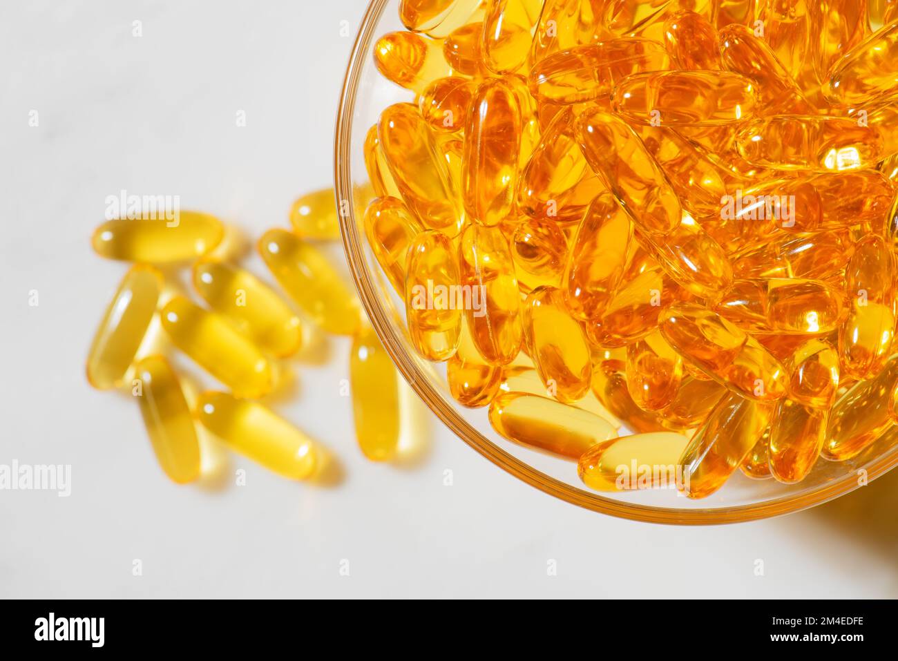 Omega-3 Fischöl Kapseln in einer Glasschüssel auf weißem Marmorhintergrund gesunde Ernährung, Lebensmittel medizinische Ergänzung, Vitamine D. Stockfoto