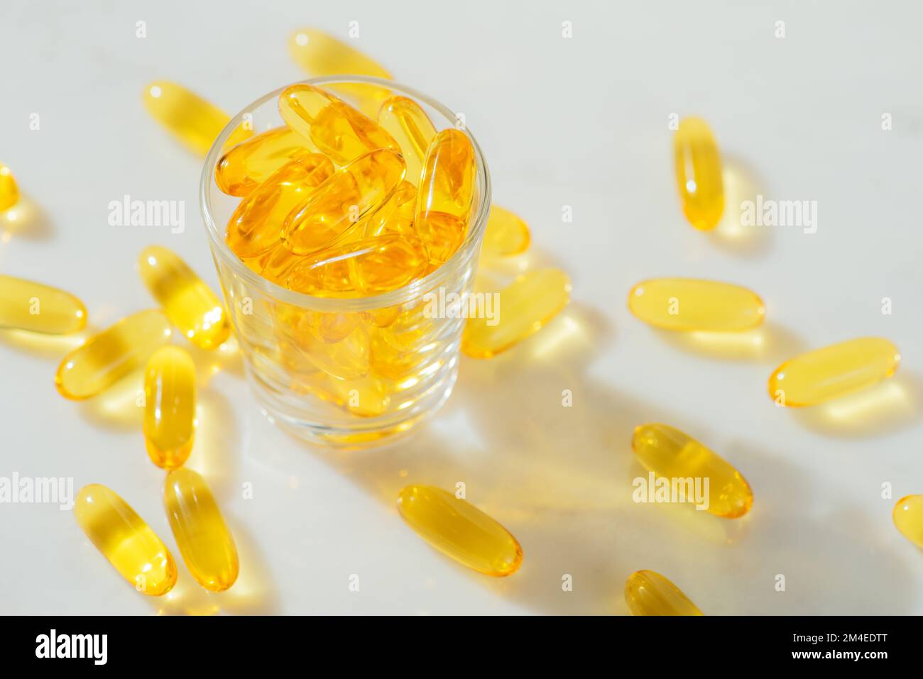 Omega-3 Fischöl Kapseln in einer Glasflasche auf weißem Marmorhintergrund gesunde Ernährung, medizinisches Nahrungsergänzungsmittel, Vitamine D, Nahaufnahme Stockfoto