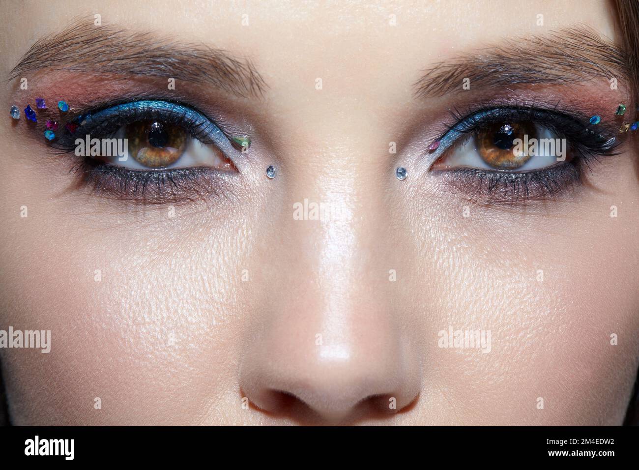 Nahaufnahme des menschlichen Frauengesichts. Frau mit natürlichem Gesicht  und Augen Beauty Make-up mit blauem Lidschatten und Strasssteinen  Stockfotografie - Alamy